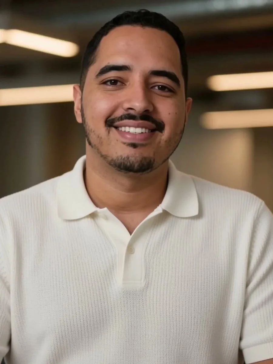 David Ospina, fundador de NexelaSoft, sonriente, con un polo color crema en una oficina.